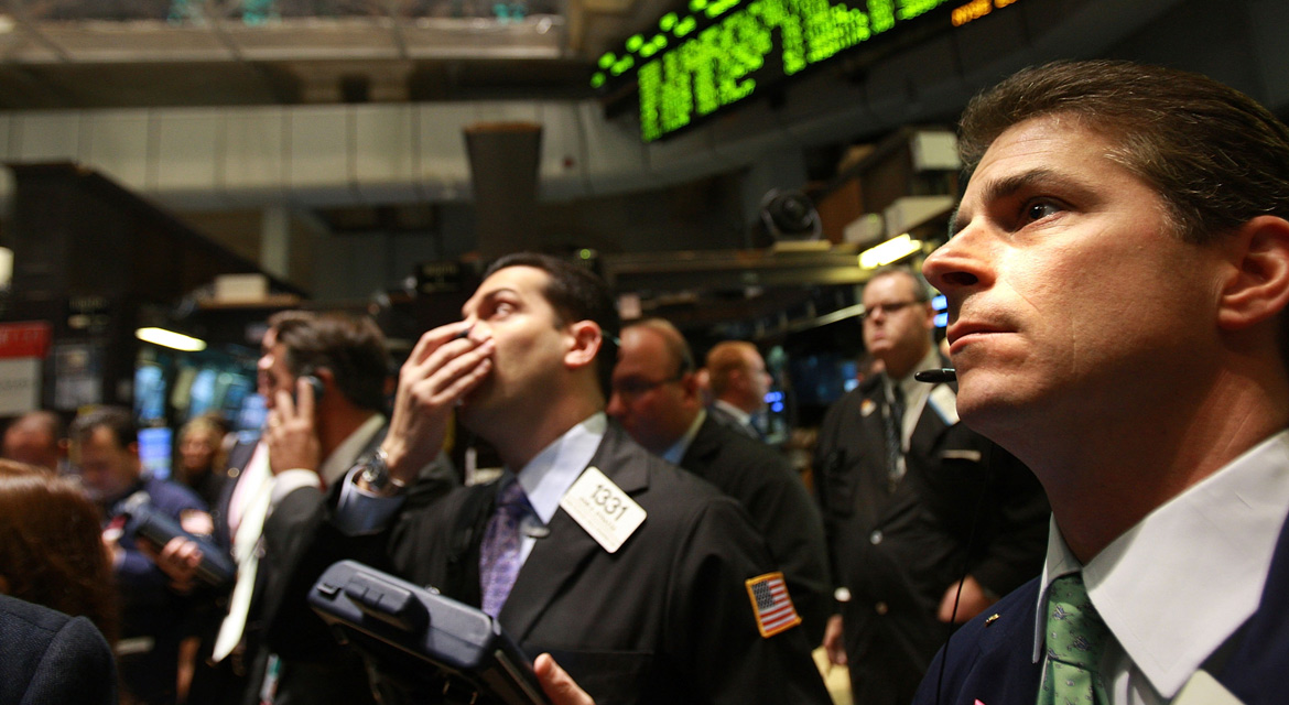 Brokers mirando las cotizaciones en la Bolsa