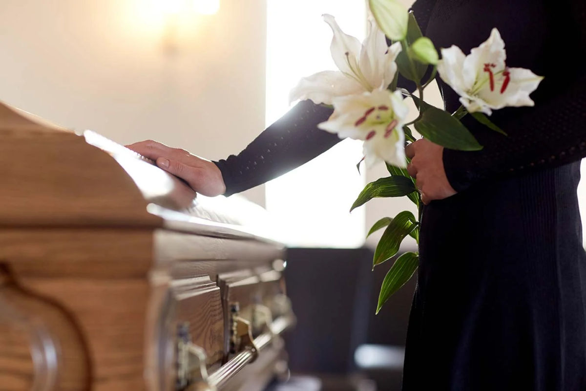 Mujer toca ataúd en un funeral