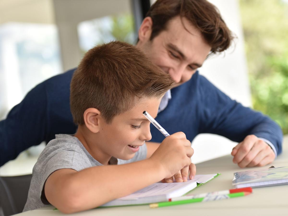 Un padre ayuda a hacer los deberes a su hijo