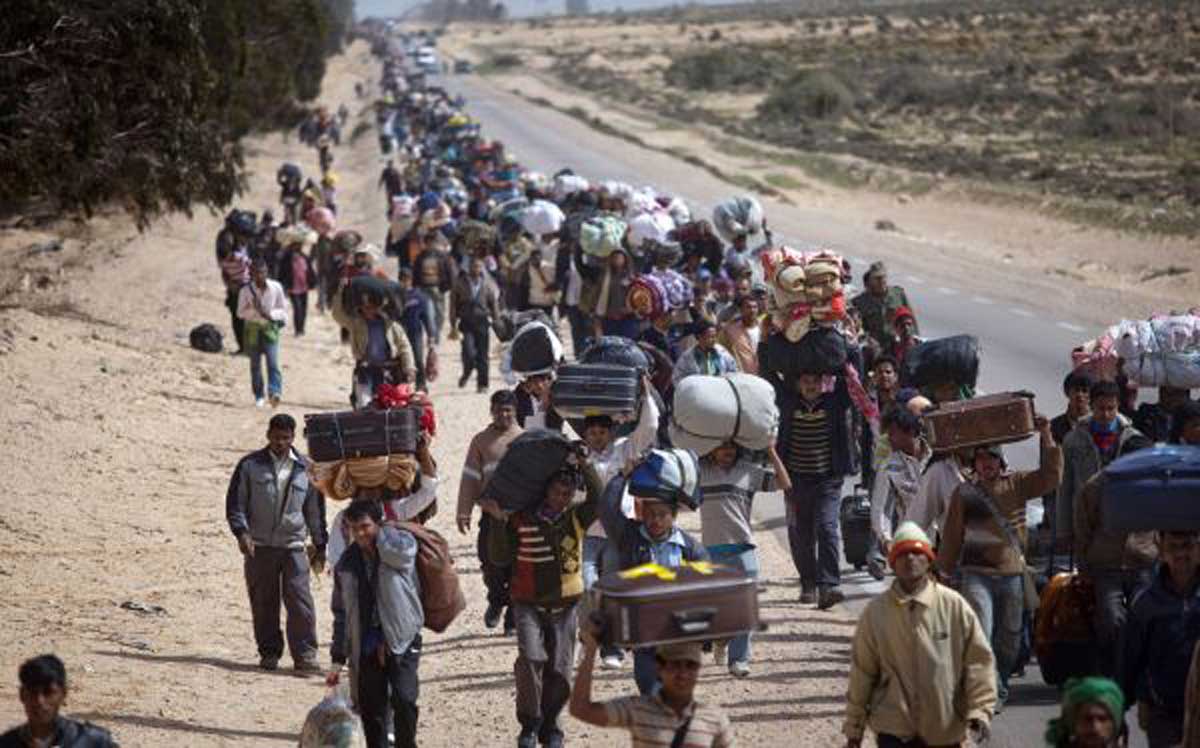 Cientos de refugiados caminan junto a una carretera